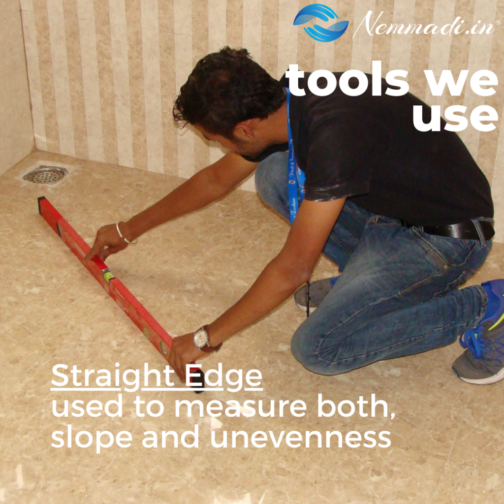 Nemmadi tools we use card: an inspector laying a straight edge across a bathroom floor to check slope